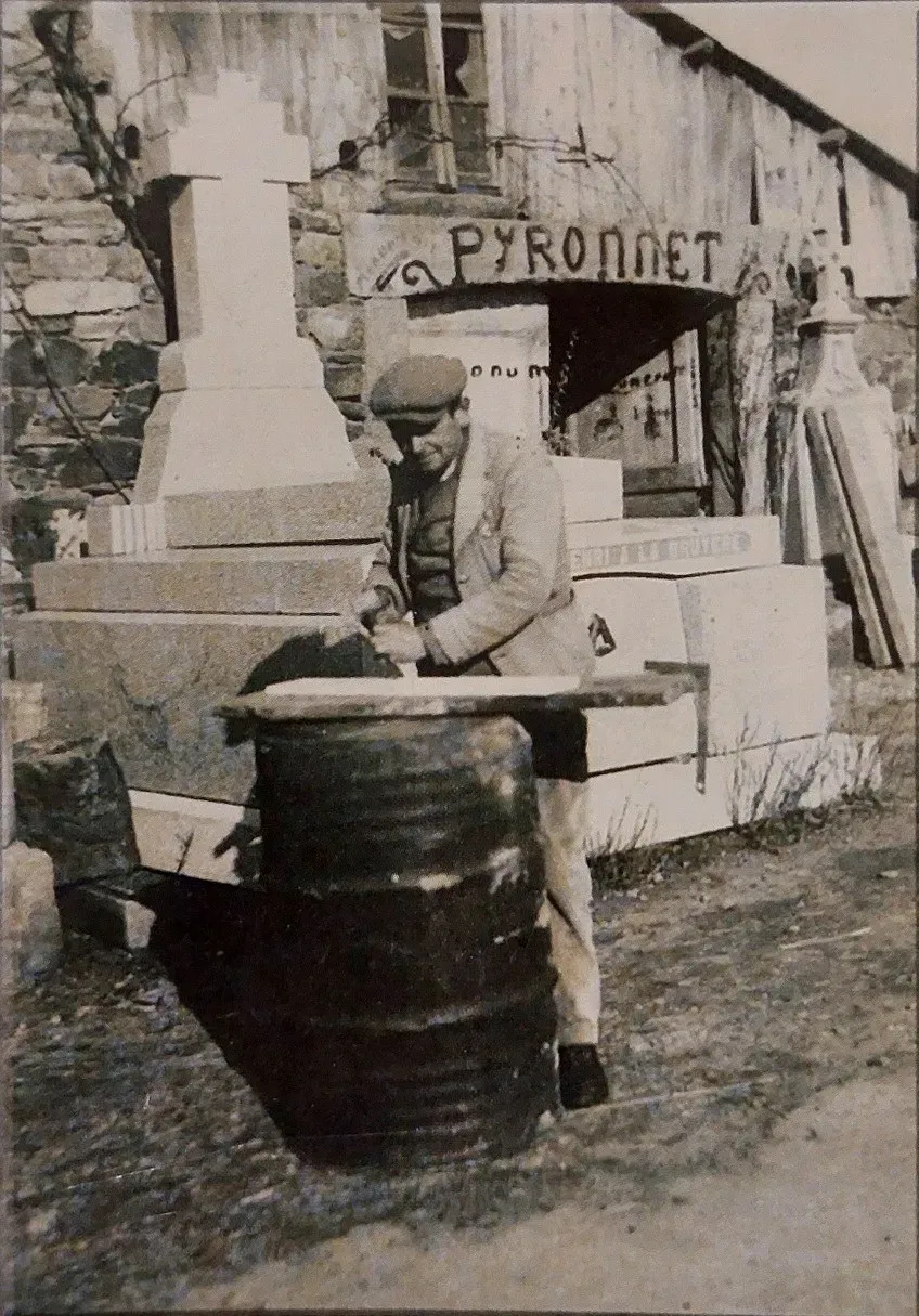 Photo d'époque en noir et blanc d'un tailleur de pierre travaillant un monument.