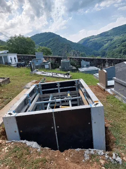 Blindage de sécurité installé pour le creusement d'un caveau dans un cimetière.